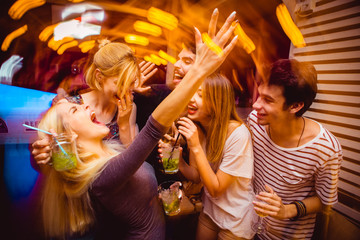 People in night club. Dancing, drinking and having fun 