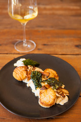 seared scallops with ricotta cavatelli and a glass of chardonnay wine