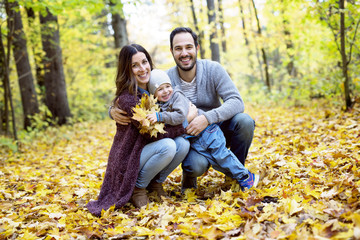 Happy family relaxing outdoors In autumn park