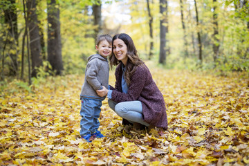 Fototapeta premium Mother with son in forest in autumn
