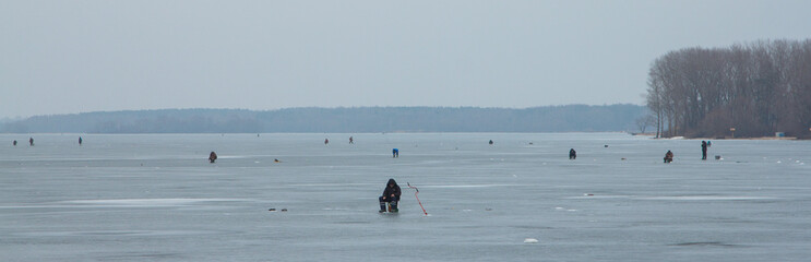 зимняя рыбалка/ рыбаки ловят рыбу подо льдом зимой