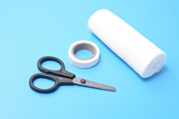medical set: a plaster, bandage scissors, isolated on a blue background.