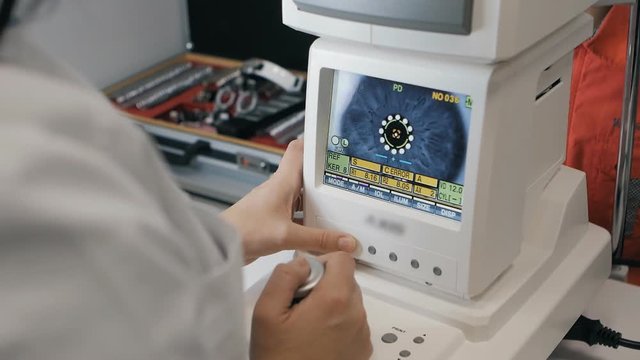 Boy checks eyesight with Keratometer at the reception of an ophthalmologist.