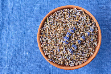 Ceramic bowl of lavander on blue fabric
