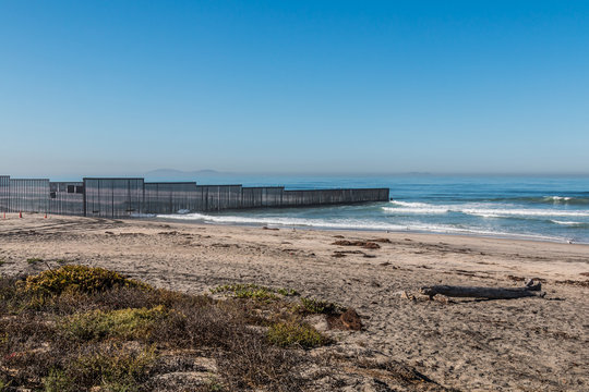 Border Field State Park beach with the international border wall separating San Diego, California and Tijuana, Mexico in the distance.
