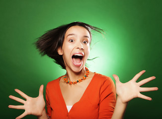 young surprised woman over green background