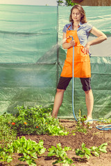 Woman watering the garden with hose