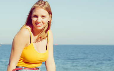 Lovely blonde girl relaxing outdoor by seaside