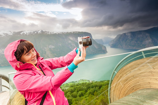 Tourist photographer with camera on Stegastein lookout, Norway