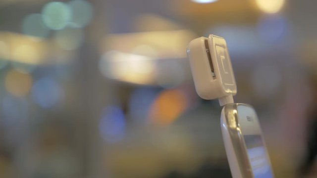 Close-up shot of a woman making payment via smartphone using magnetic mobile card reader