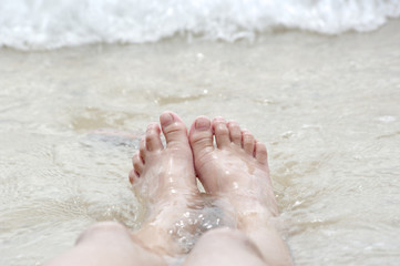 Fototapeta na wymiar relax foot sea and small waves
