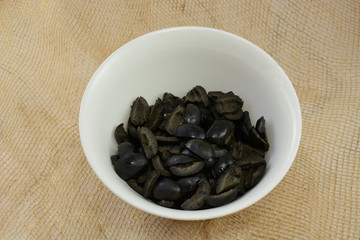 Canned pitted olive slices in white bowl