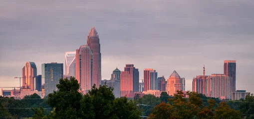 Photo sur Plexiglas construction de la ville A luminescent and colorful sunrise hitting the buildings that make up the Charlotte, North Carolina skyline. 