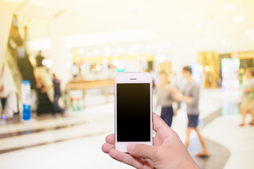 Man hand holding smartphone black screen with blur shopping zone background