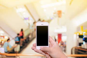 Man hand holding smartphone black screen with blur shopping zone background