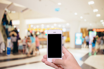 Man hand holding smartphone black screen with blur shopping zone background