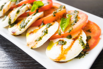 Tomato and mozzarella cheese salad in white plate