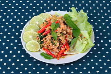 Fried spicy basil with minced pork topped sliced green lemon and and lettuce is top ten of popular Thai food.