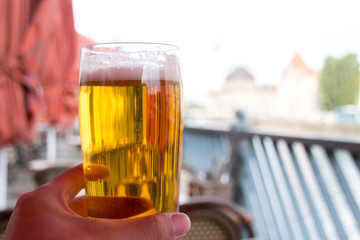 テラス席で飲むビール。夏の旅先の思い出。グラスを持つ男性主観視点