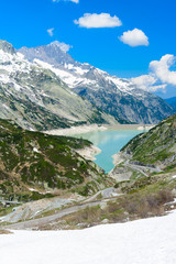 Naklejka na ściany i meble Grimsel Pass. Scenic view from the grimsel pass in Switzerland down to the turqouise lake with the dam.