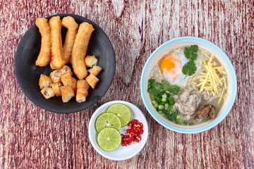 Rice porridge with mined pork and chicken lever served with side dish as Patongko (deep-fried dough stick) and spicy sour filling.