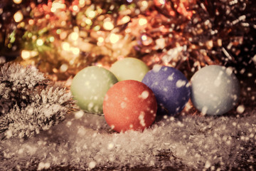 Fototapeta na wymiar Vintage christmas background with multicolor christmas decorations on snow. Retro toned.