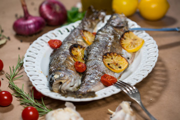 delicious trout fish baked with lemon, tomatoes and spices