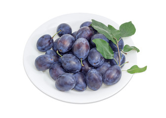 Plums on white dish on a light background