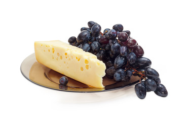 Piece of Swiss-type cheese and blue table grapes