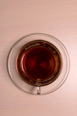 transparent glass cup with tea and saucer top view