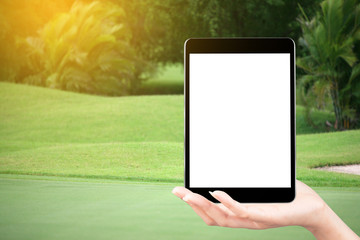 Touch screen in hand, tablet on golf club - soft blur background