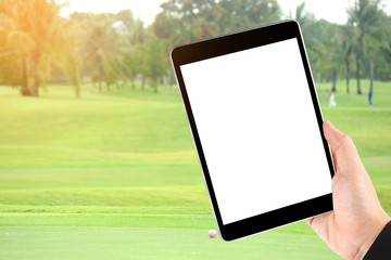 Touch screen in hand, tablet on golf club - soft blur background