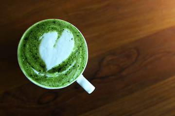 Matcha Green Tea latte cup on wooden table in Coffee Shop