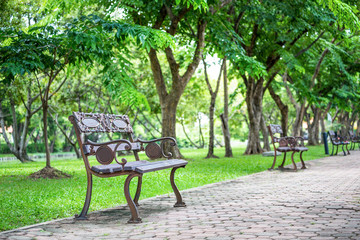 Fototapeta na wymiar Vintage iron seat on footpath inside green park