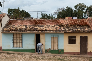 Man repairing house door on street in Trinidad, Cuba