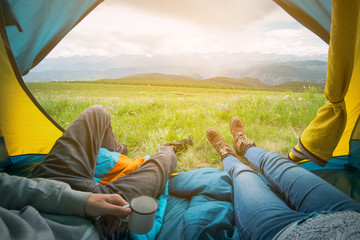 Two people lying in tent with a view of mountains. Altay, Russia.