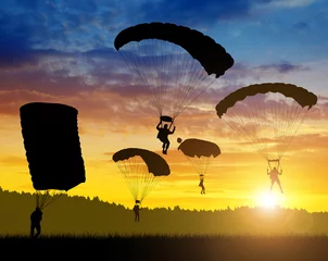 Papier peint adhésif Sports aériens Silhouette skydiver parachutist landing at sunset