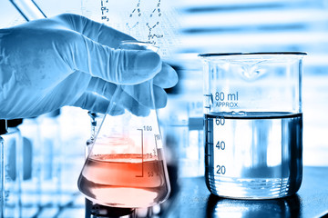 Flask in scientist hand with test tubes in laboratory 