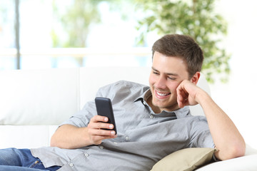 Man using a smartphone sitting on a couch