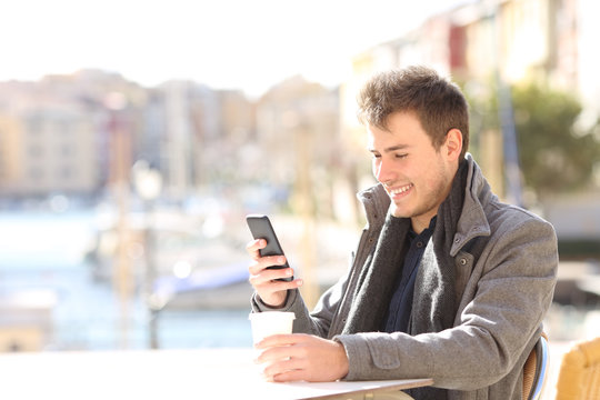 Man Using A Smart Phone In A Coffee Shop In Winter