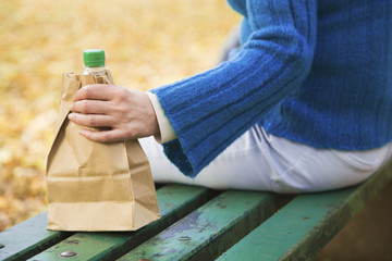 Close up of female hands holding shopping bag with bottle of alcohol drink