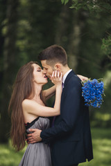 Young beautiful couple, girl with perfect dress posing in park