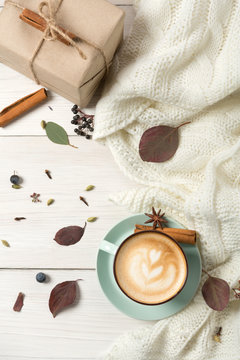 Autumn cappuccino coffee cup on white wood background