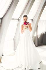 Wonderful bride with a luxurious white dress posing in the old town