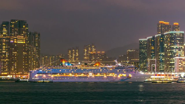 Shyline panorama timelapse day to night with towers and cruise liner in West Kowloon, Hong Kong.
