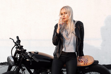 Naklejka na ściany i meble Biker woman in leather jacket on motorcycle
