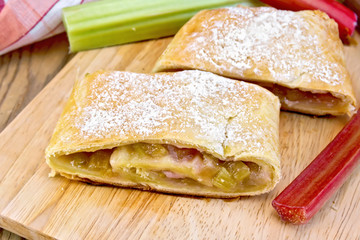 Strudel with rhubarb and napkin on wooden board
