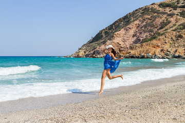 Fototapeta na wymiar Beautiful stress free woman with blue dress at the beach