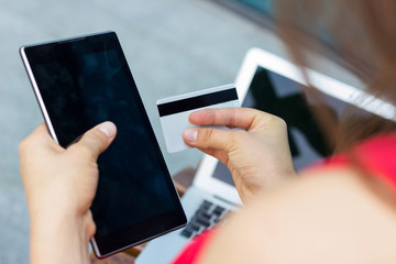 Young woman using her credit card on the street