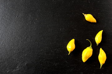 yellow ghost chili peppers on a slate plate